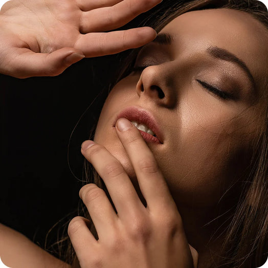 Imagem com detalhe de uma mão a tocar numa face feminina